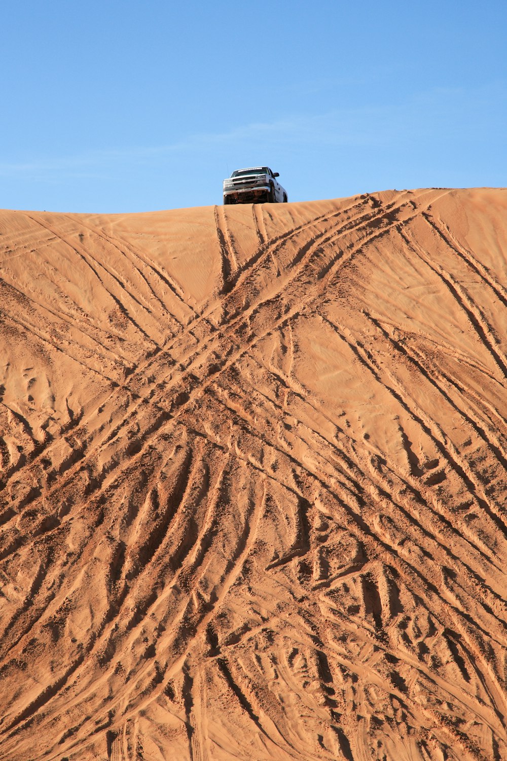 Schwarzer SUV auf braunem Sand