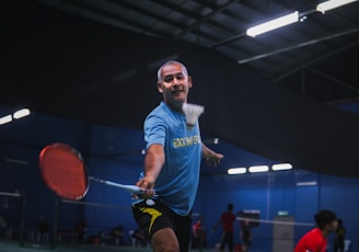 man in blue crew neck t-shirt and black shorts holding red basketball