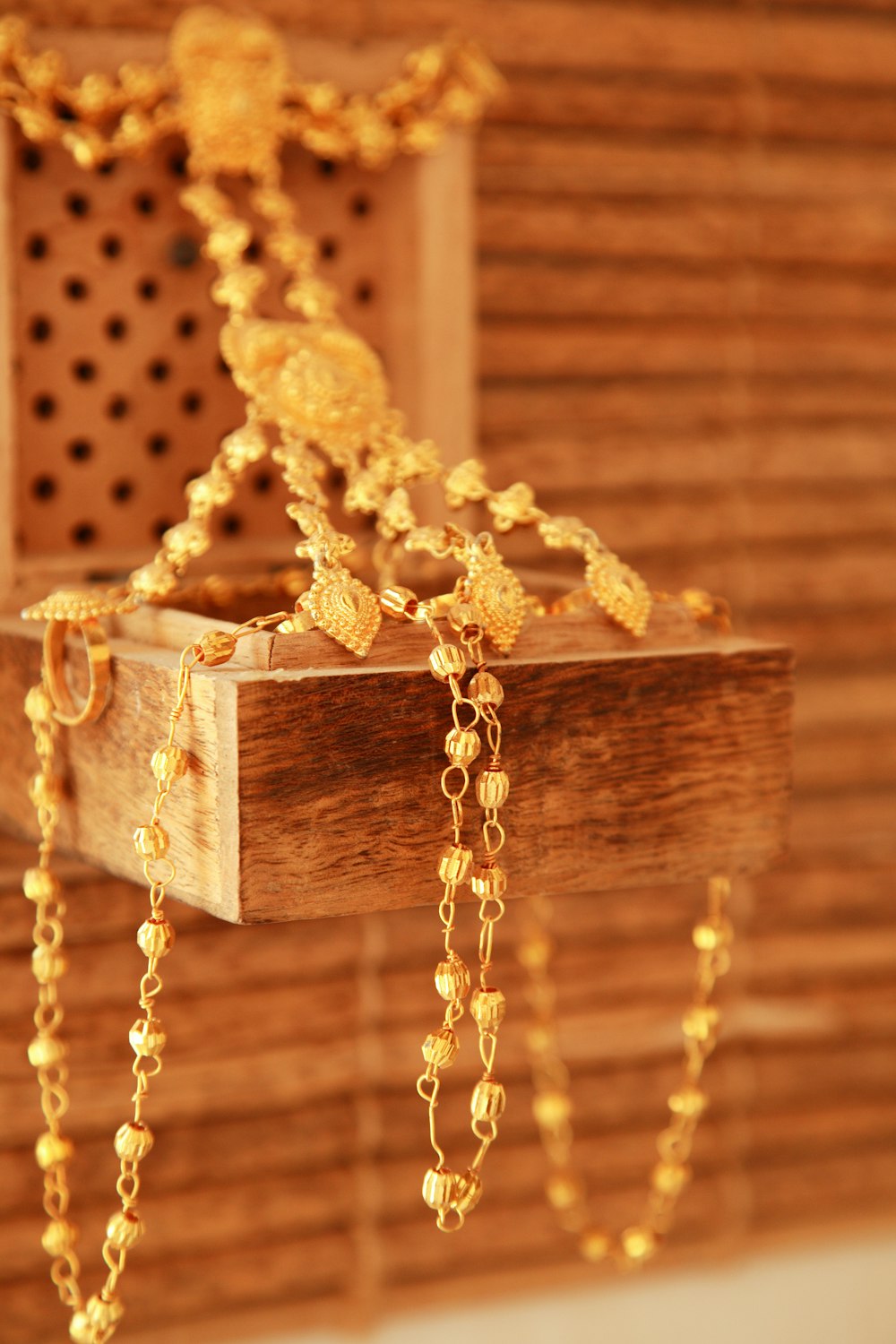 gold and white beaded necklace on brown wooden box