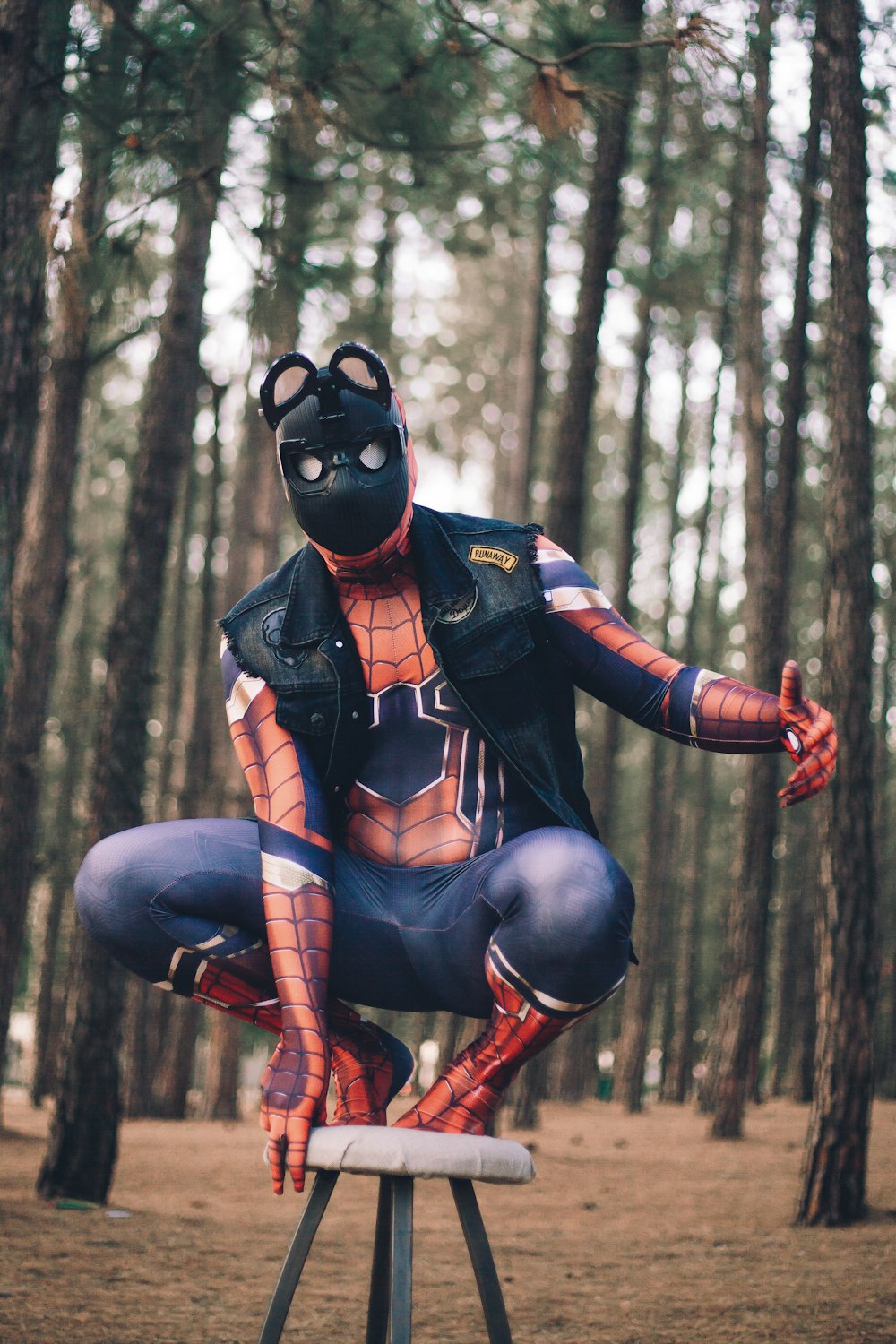 Femme en costume d’homme araignée noir et rouge debout sur la forêt pendant la journée