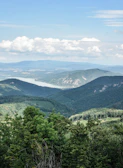 A panoramic view of lush green mountains with a winding river.