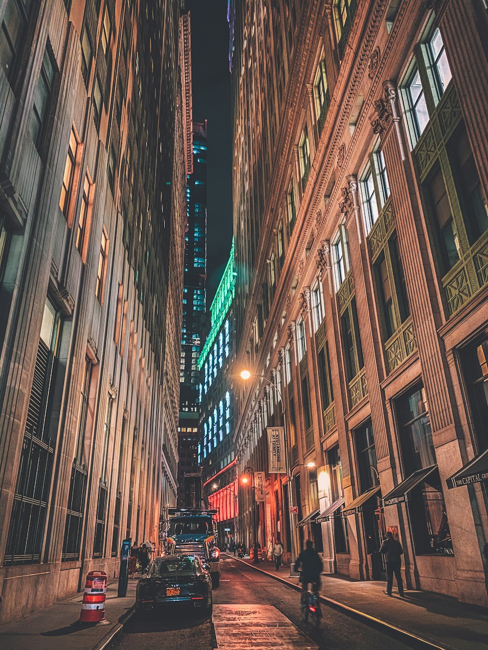 people walking on street between high rise buildings during night time