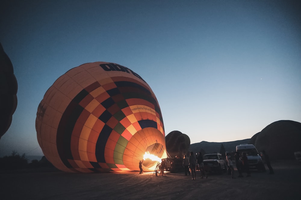 people standing near hot air balloon during night time