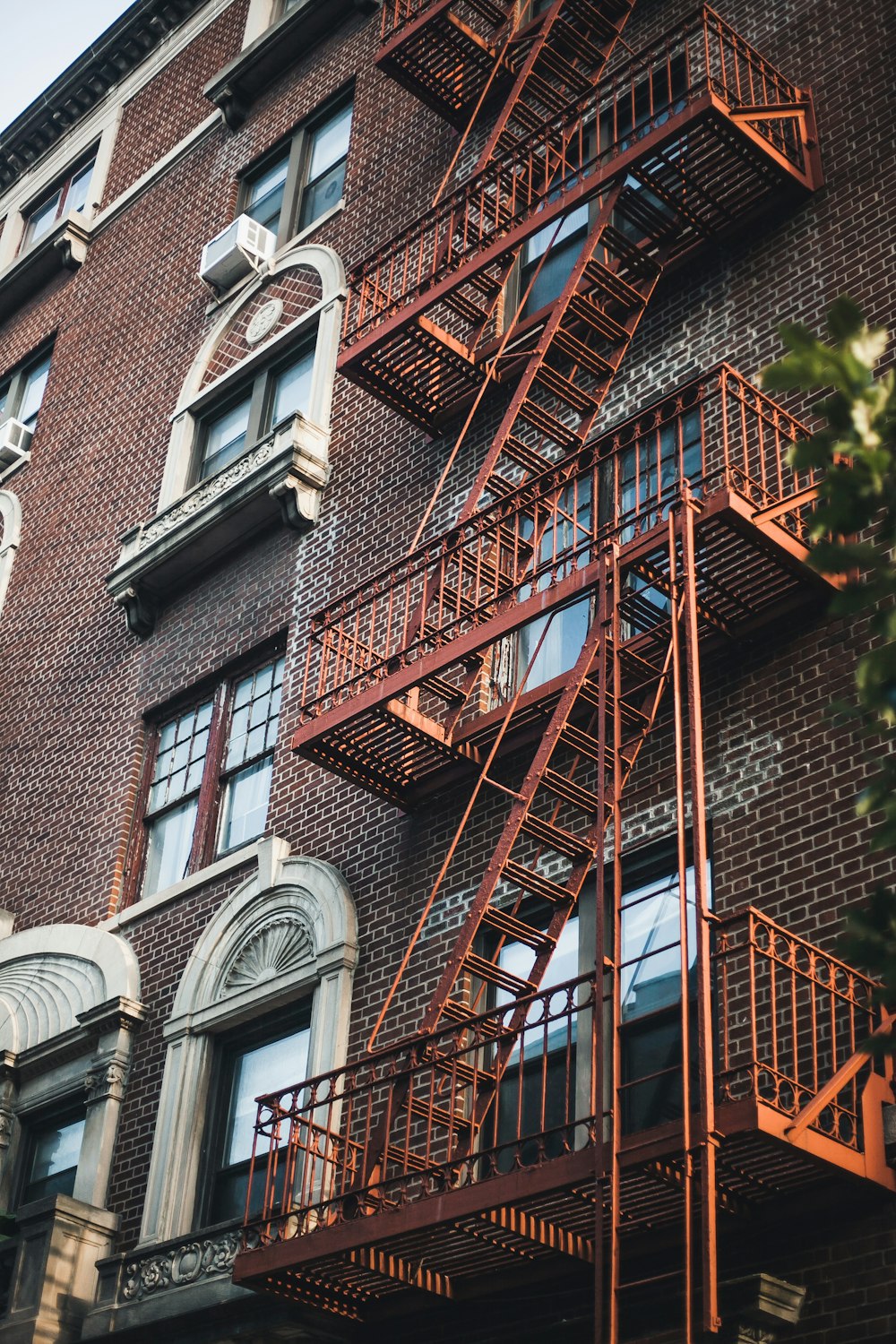 brown brick building with red metal window grills