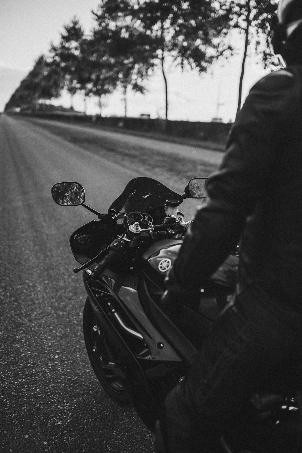 grayscale photo of man riding on motorcycle