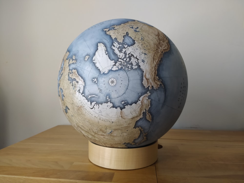 blue and white globe on brown wooden table