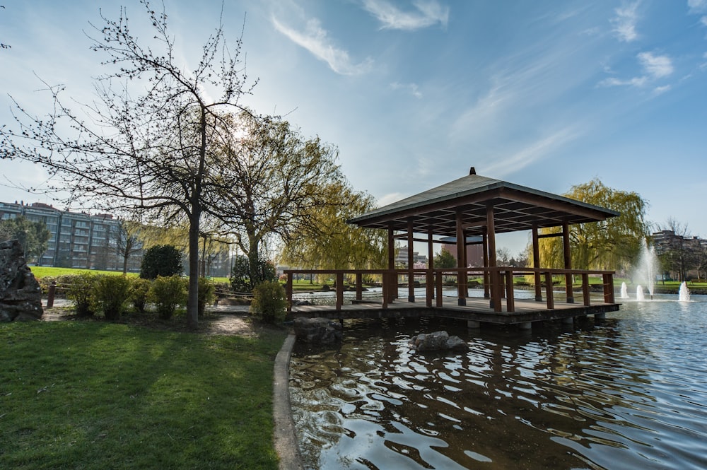 Casa de madera marrón cerca del río bajo el cielo azul durante el día