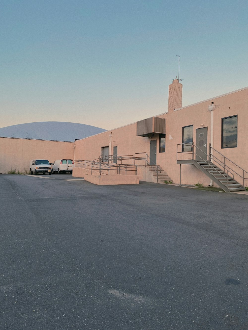 white car parked beside beige concrete building during daytime