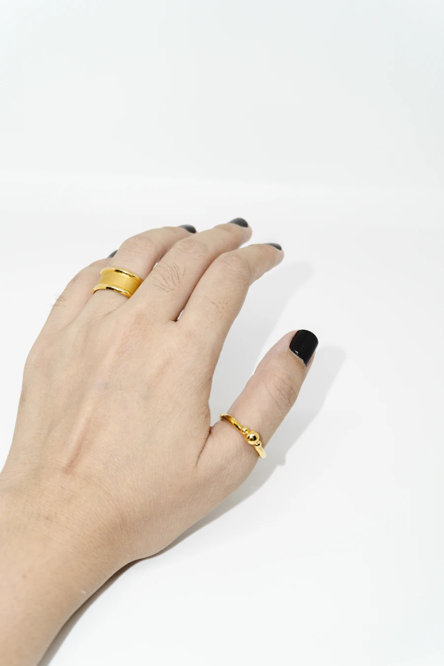 Hand wearing two slim gold rings