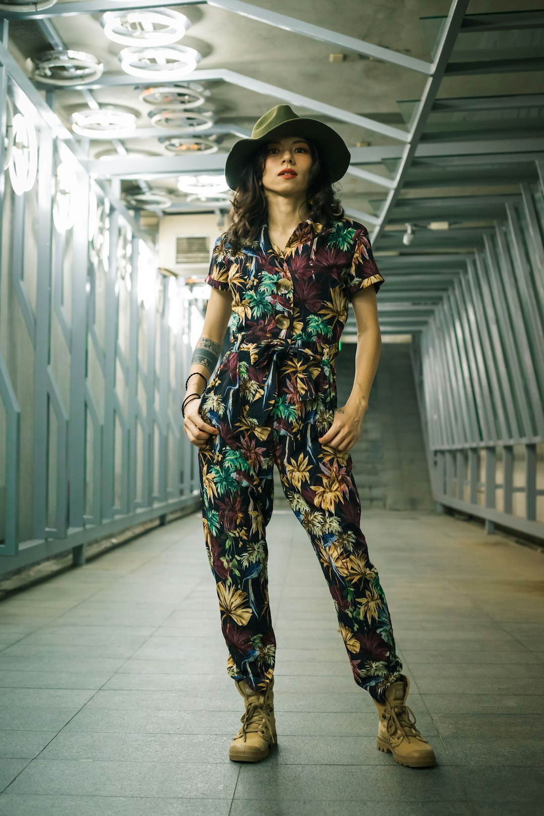 woman in black green and red floral dress standing on white floor tiles