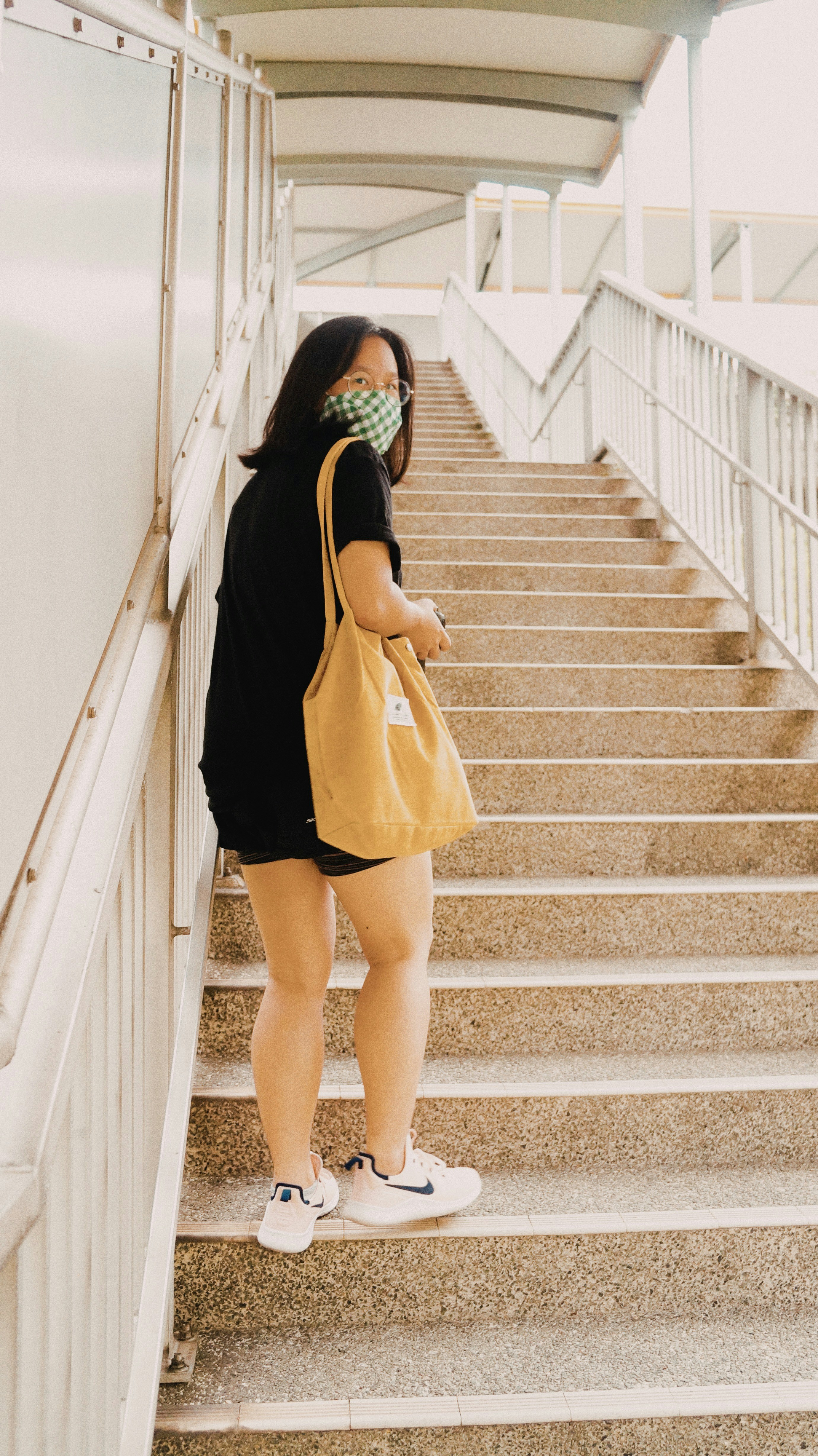 woman in black long sleeve dress and black hijab standing on gray concrete staircase