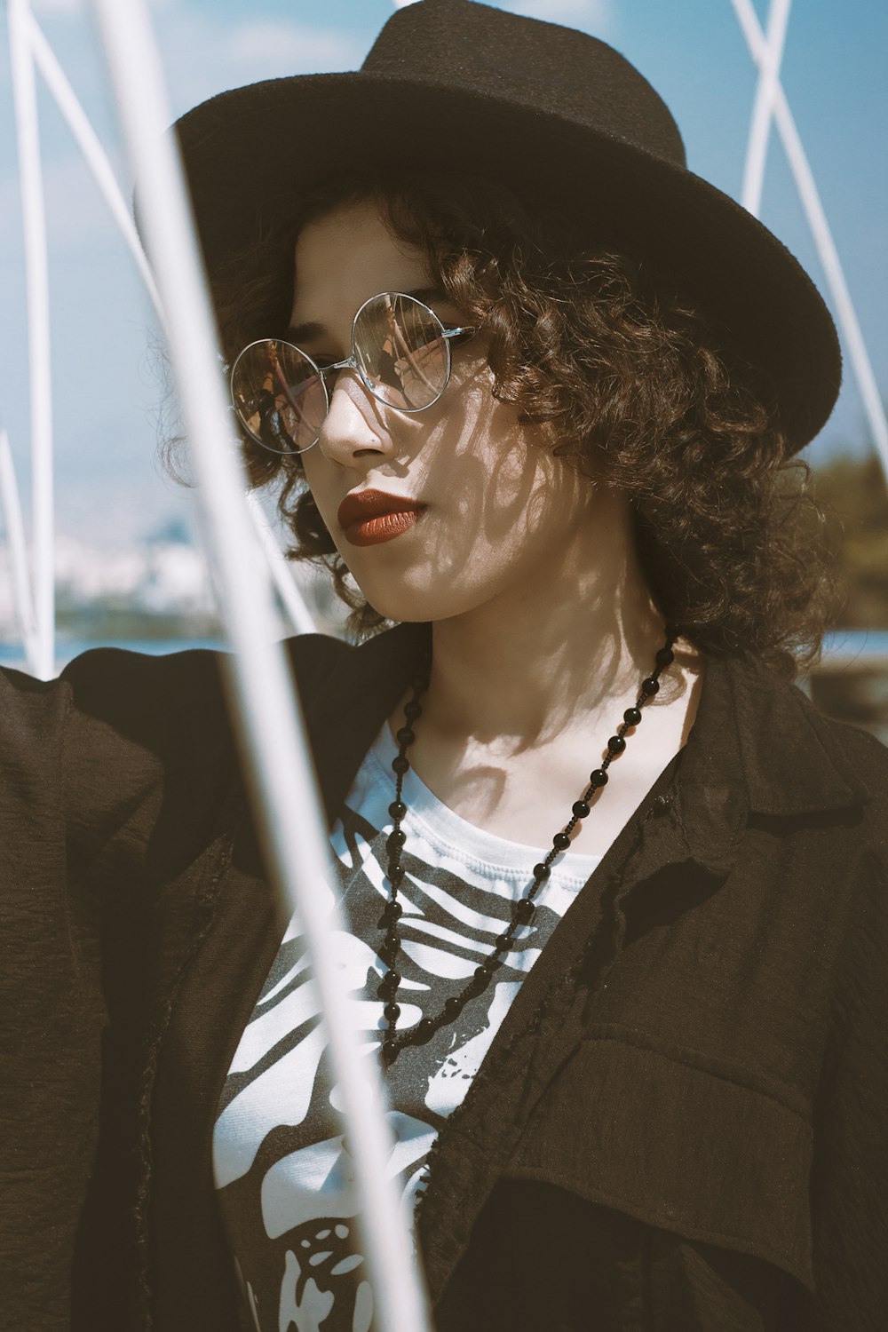 woman in black coat wearing black hat and black framed eyeglasses