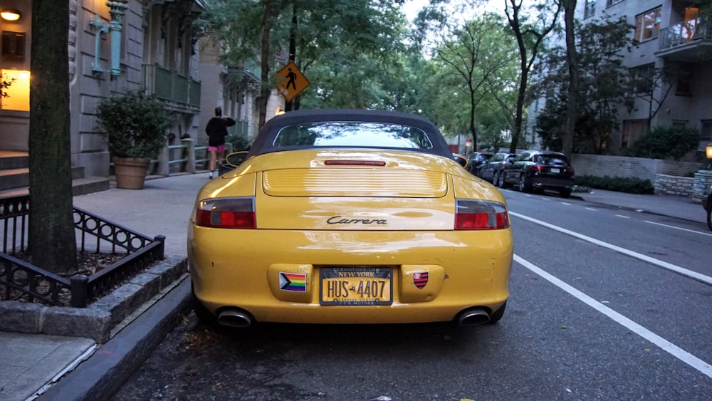 yellow porsche 911 parked on street during daytime