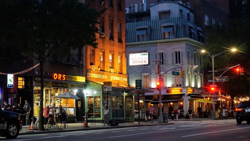 people walking on sidewalk near building during night time