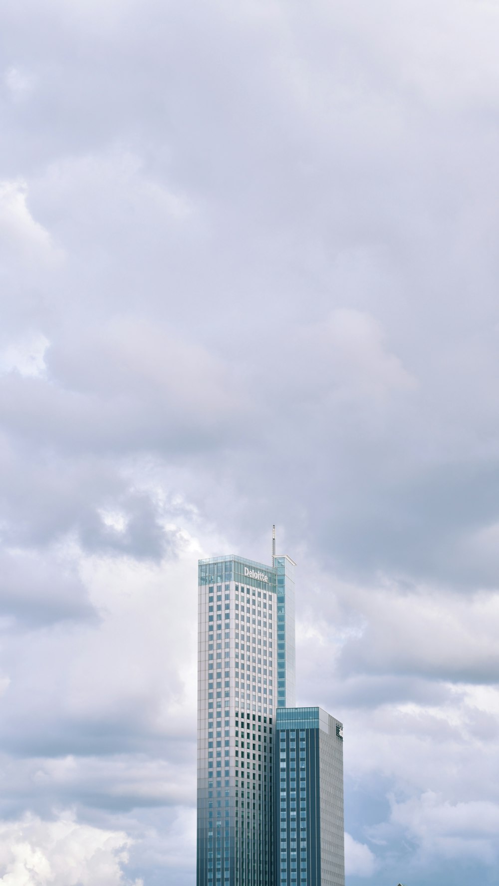 white concrete building under white clouds during daytime