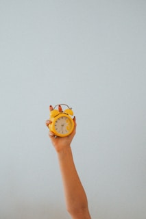 person holding yellow and white analog watch