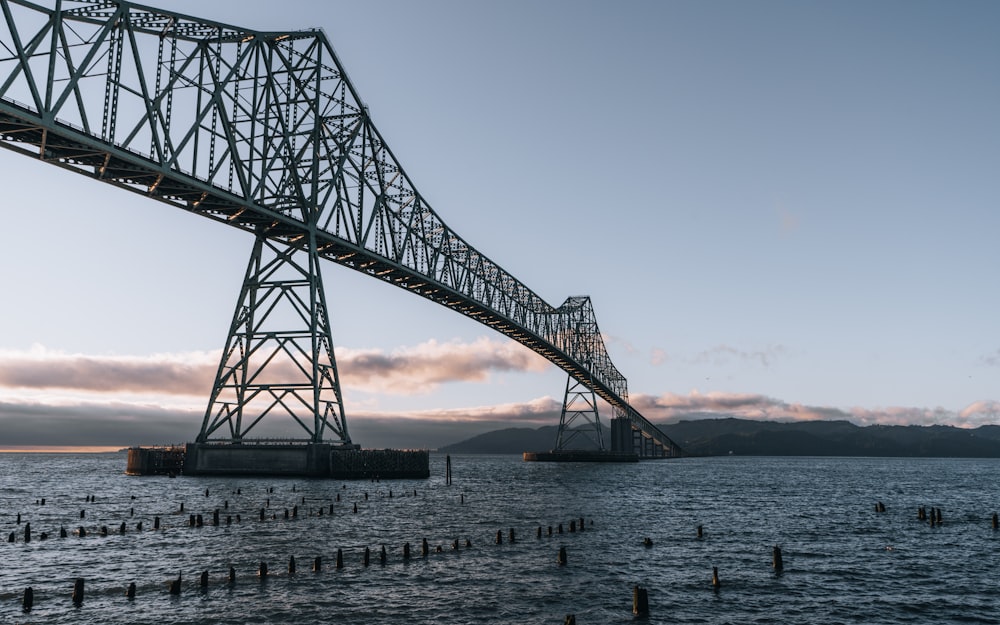 Puente de metal gris sobre el mar durante el día