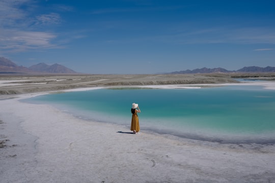 woman in yellow dress standing on beach during daytime in Qinghai China