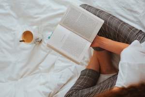 person in black and white striped long sleeve shirt reading book