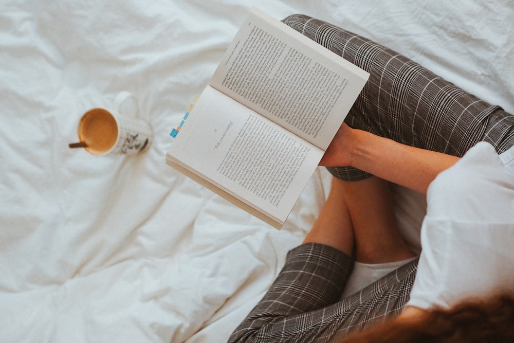 person in black and white striped long sleeve shirt reading book