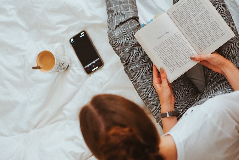 person in white shirt reading book