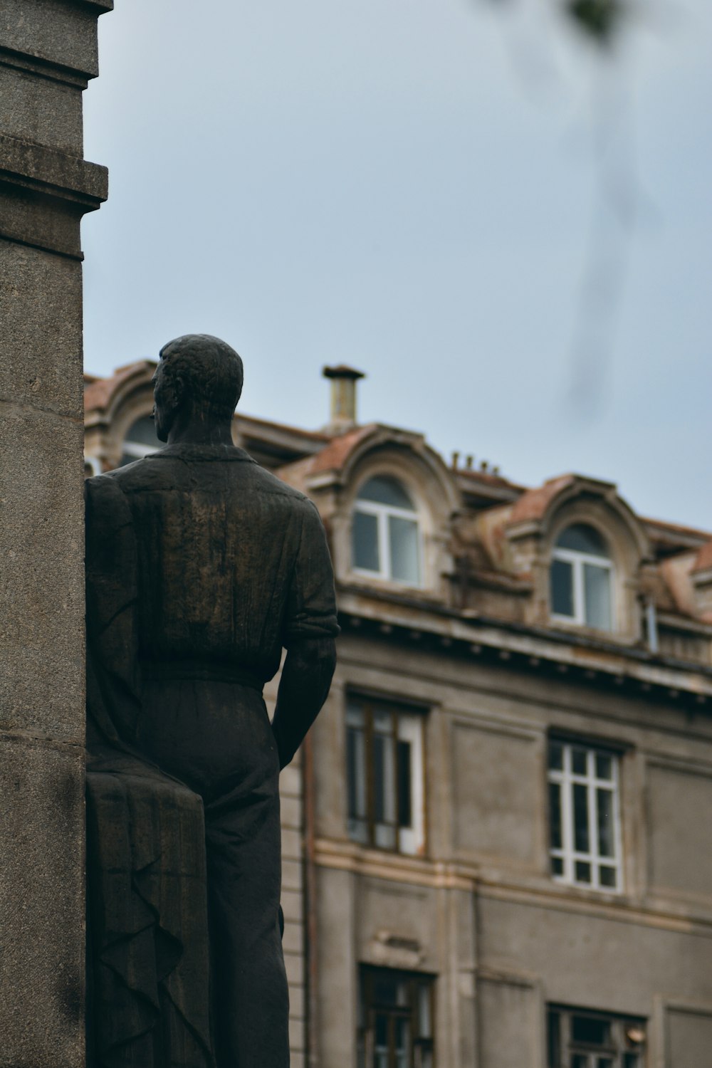 Hombre con chaqueta negra de pie cerca del edificio durante el día