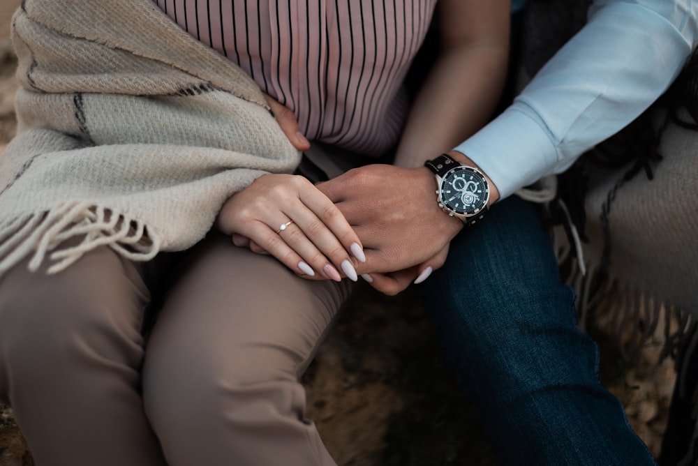 person wearing silver link bracelet round analog watch