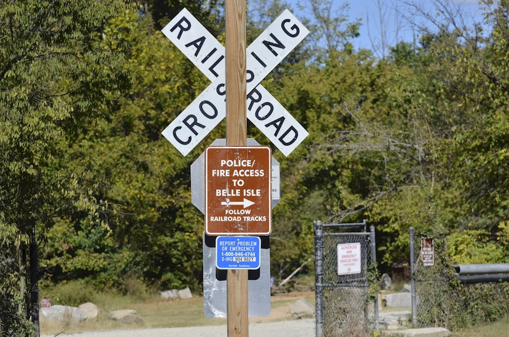 brown wooden road sign near green trees during daytime