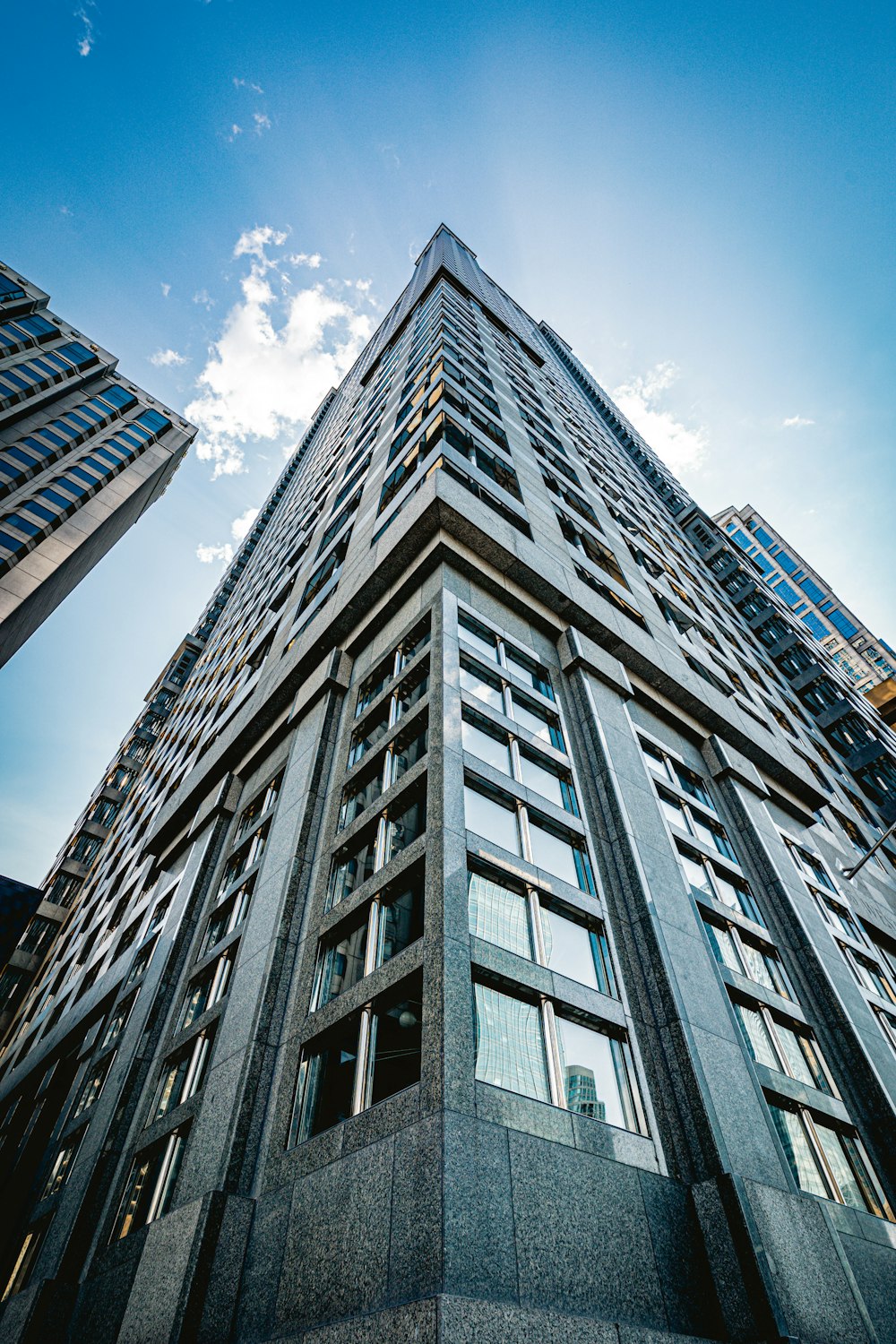 low angle photography of gray concrete building under blue sky during daytime