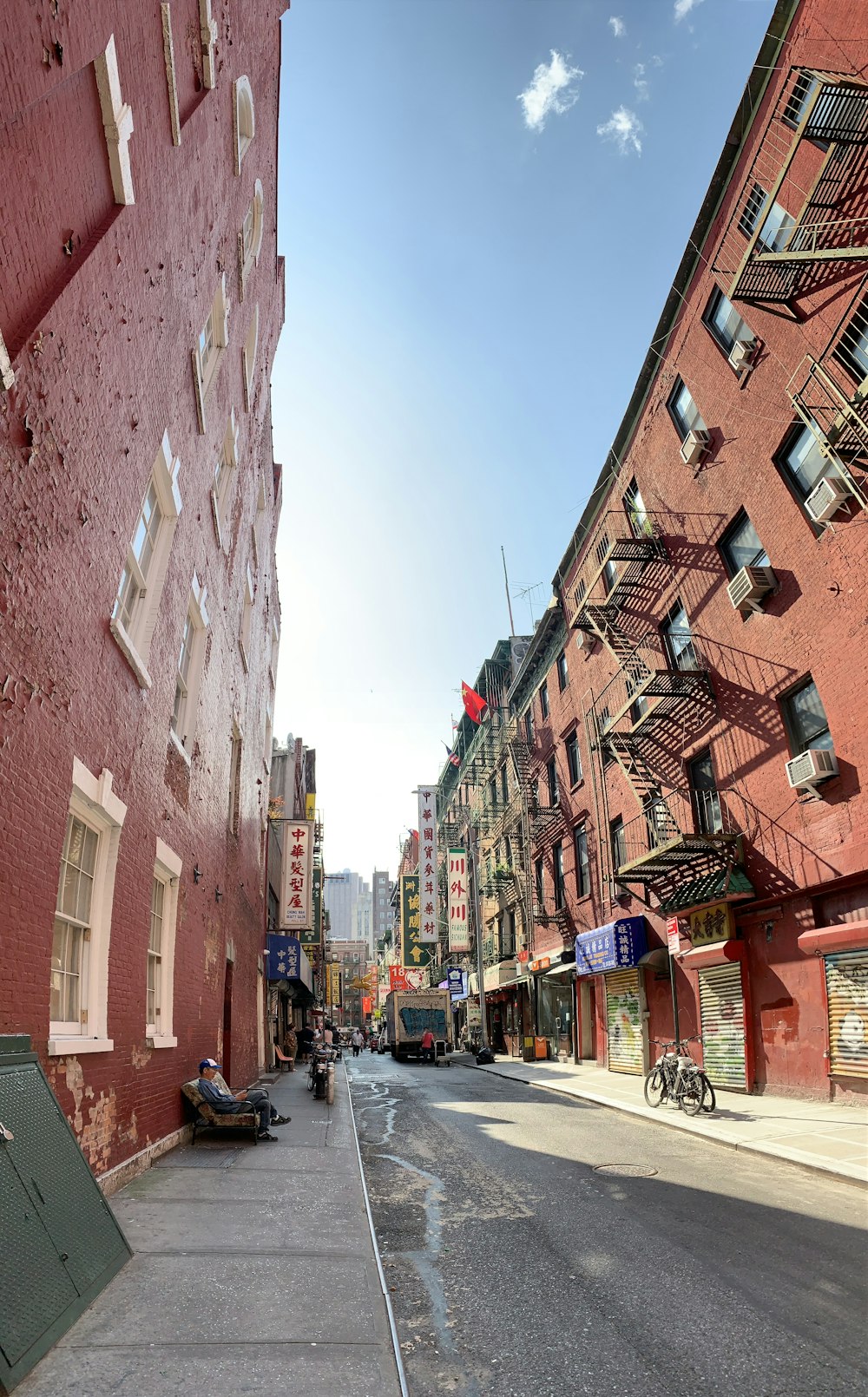 cars parked on side of the road between buildings during daytime