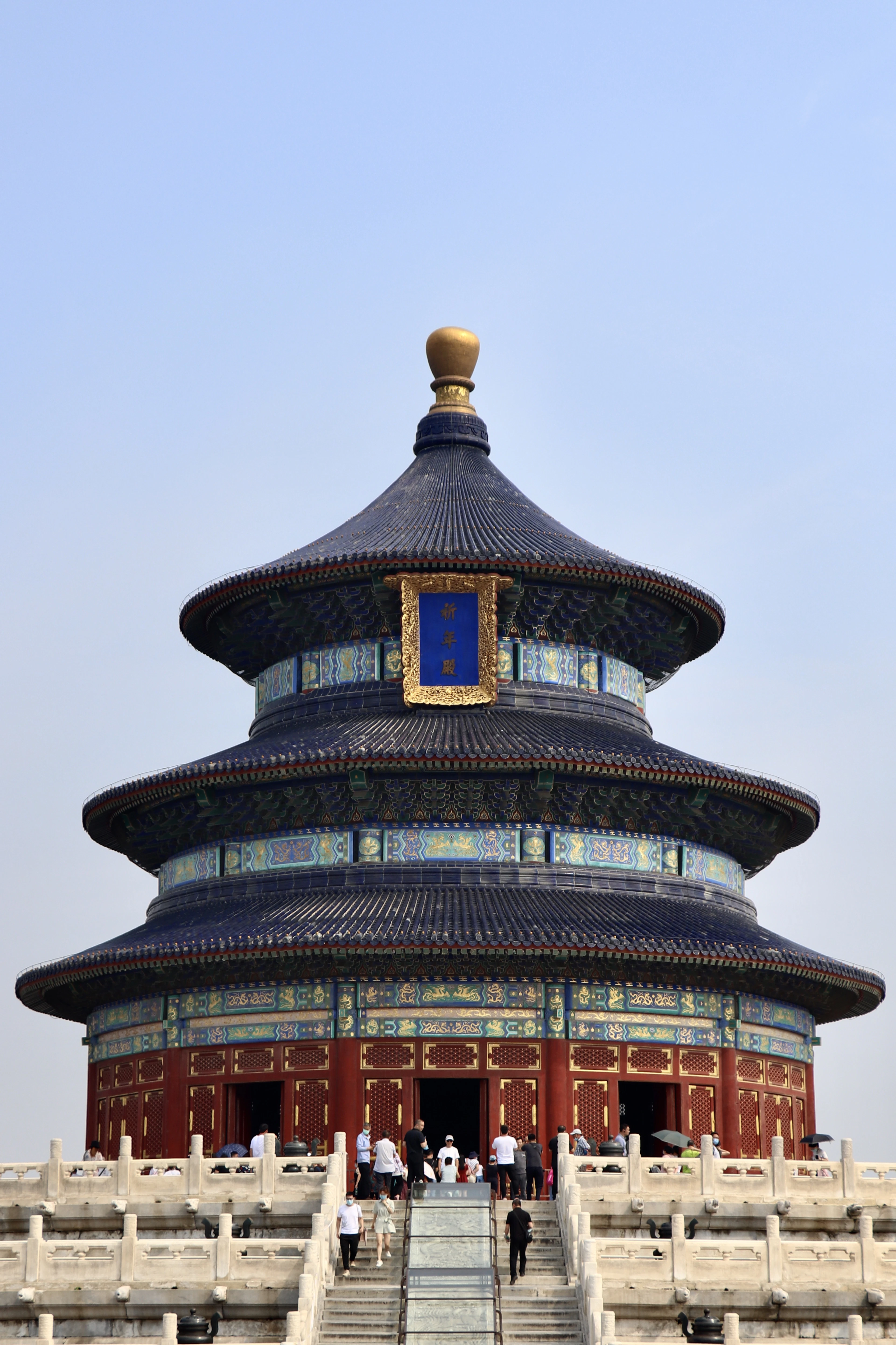 The Temple of Heaven's triple-eaved blue roof rises above its marble terraces under a clear blue sky.