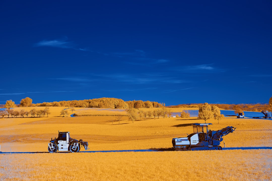 white and black truck on brown field under blue sky during daytime