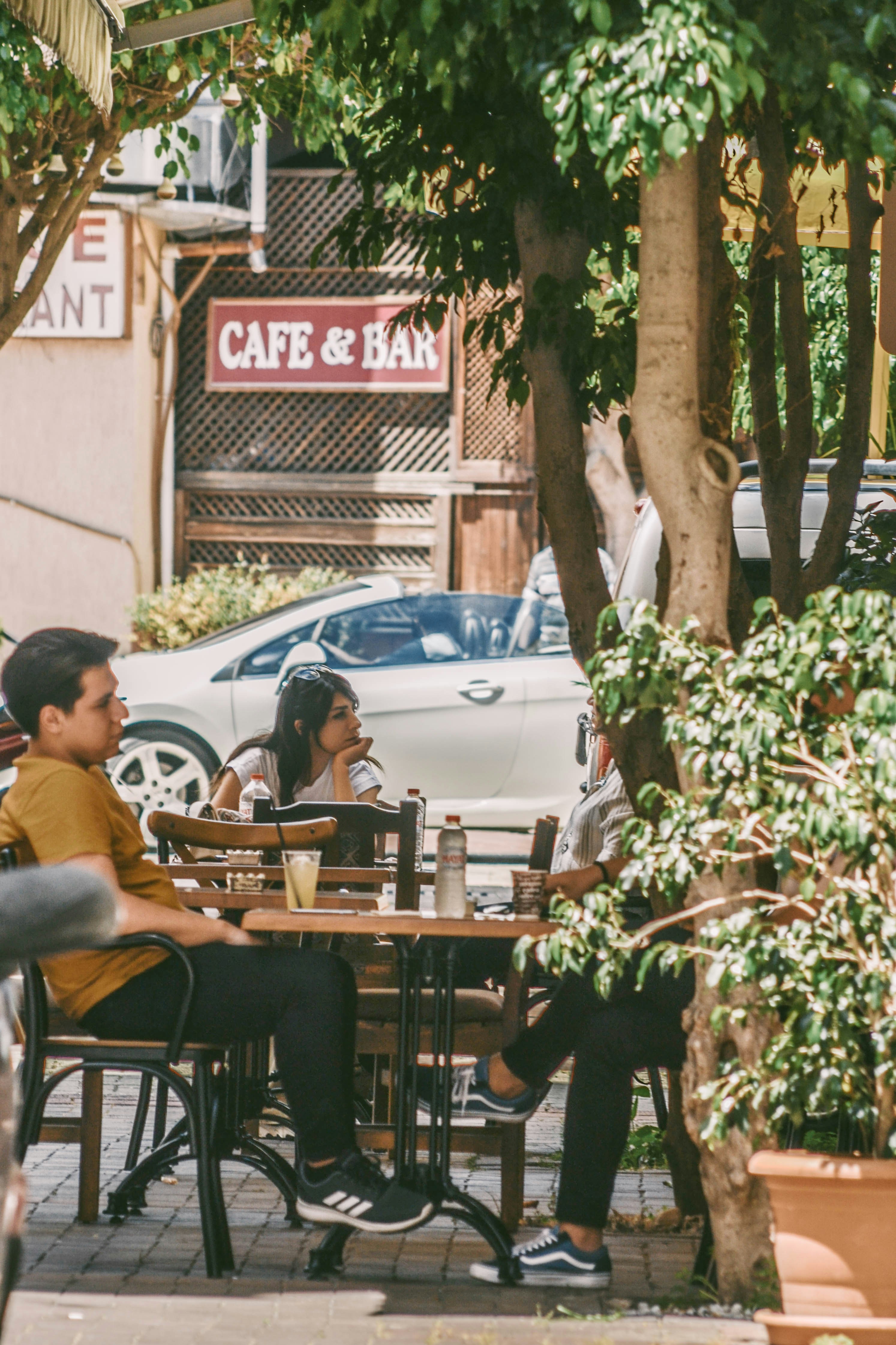 man in black jacket sitting on chair near brown wooden table