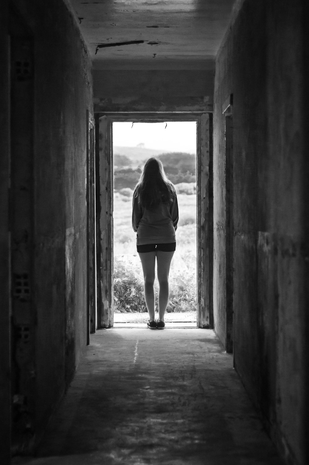 woman in black long sleeve shirt and black skirt standing on hallway