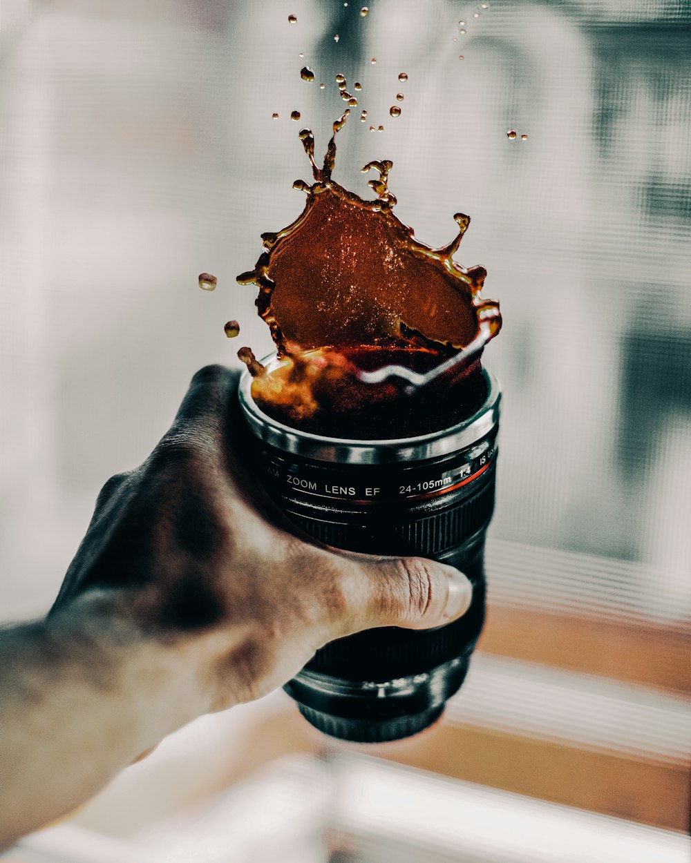 person holding black and brown bottle