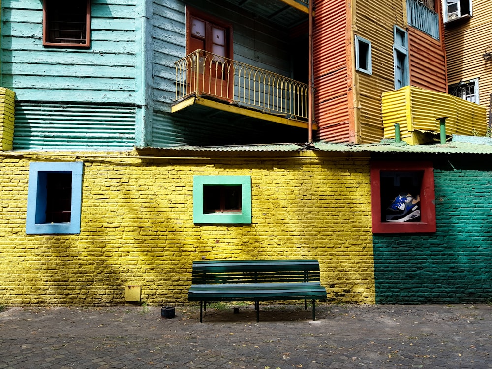 brown wooden bench beside brown concrete house