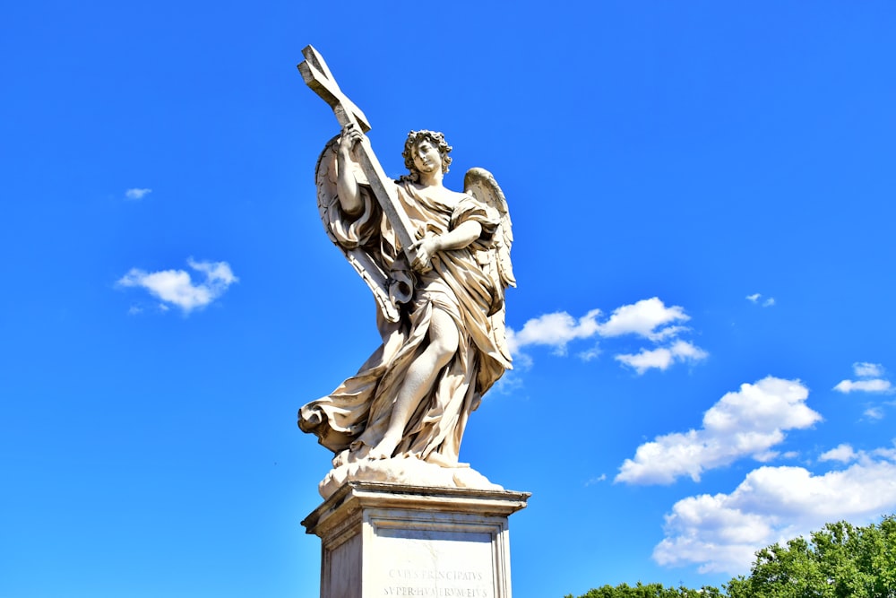 Hombre sosteniendo una estatua de libro bajo el cielo azul durante el día