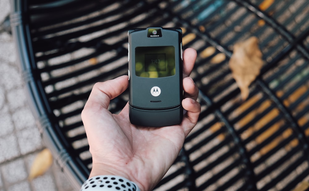 black samsung flip phone on persons hand