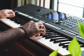 person playing black and white electric keyboard