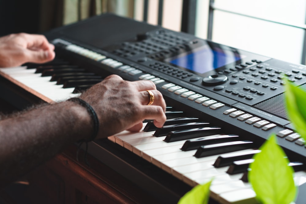 person playing black and white electric keyboard