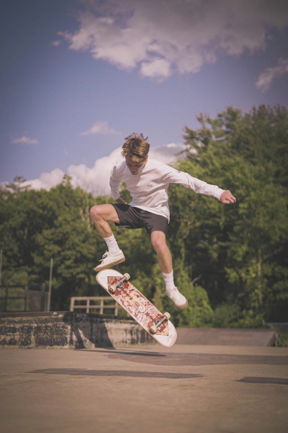 man in white t-shirt and black shorts jumping on mid air during daytime