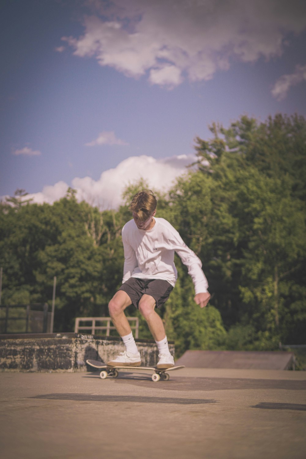 man in white long sleeve shirt and black shorts running on track field during daytime