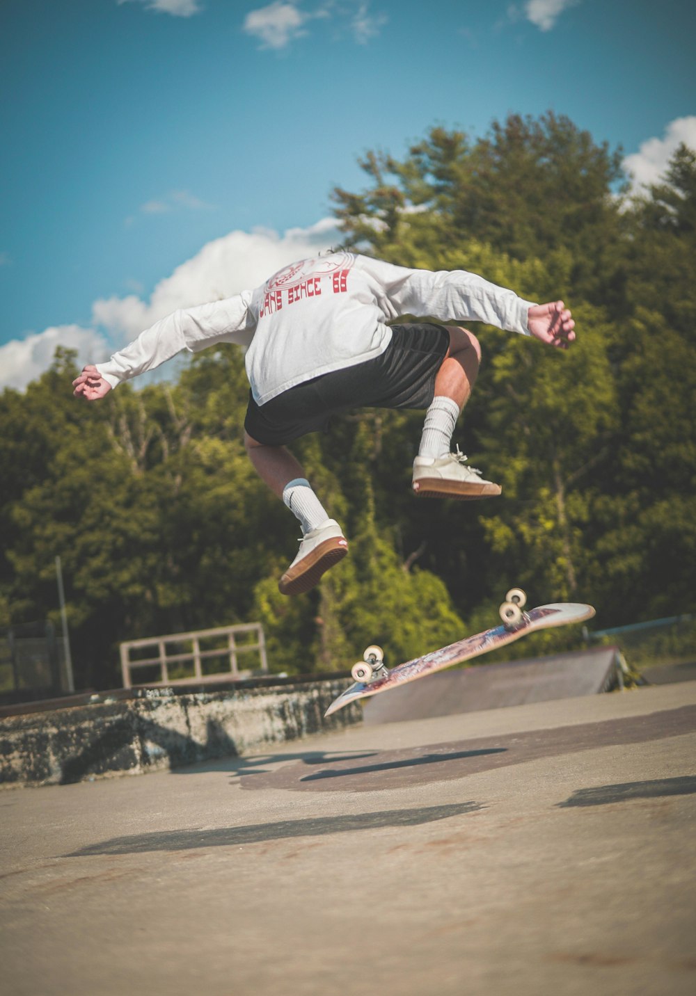 man in white and red hoodie and black pants riding skateboard during daytime