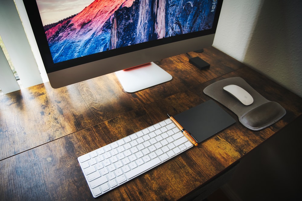 silver imac on brown wooden table