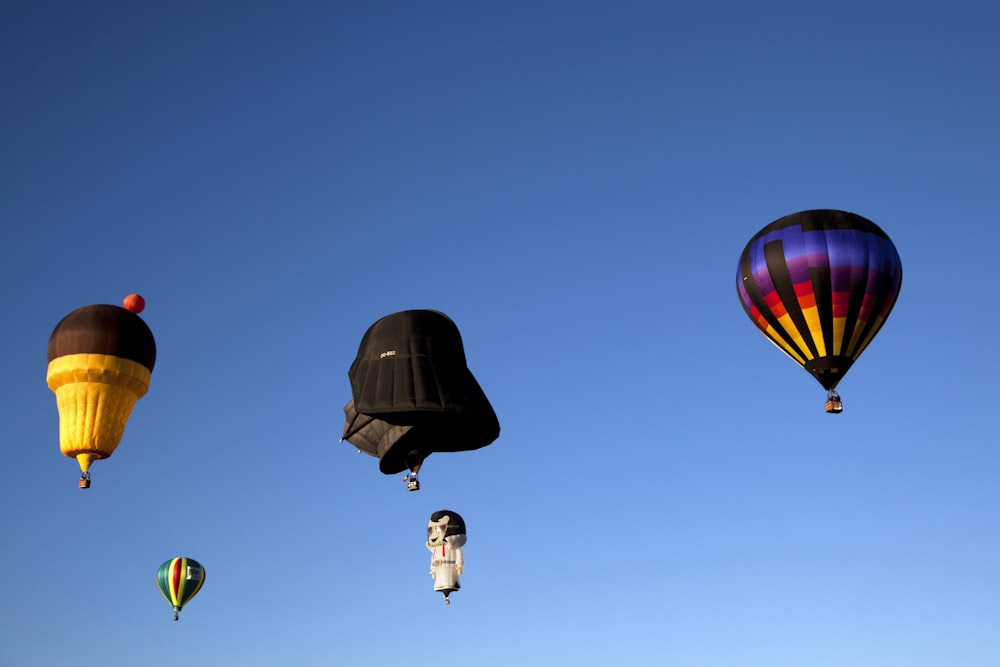 Schwarze Heißluftballons in der Luft unter blauem Himmel tagsüber