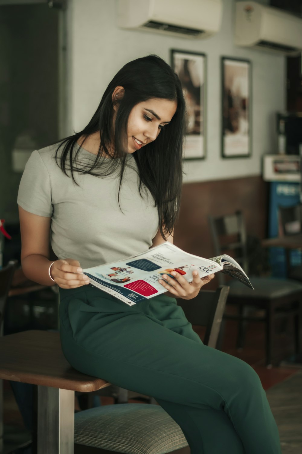 woman in white t-shirt reading magazine