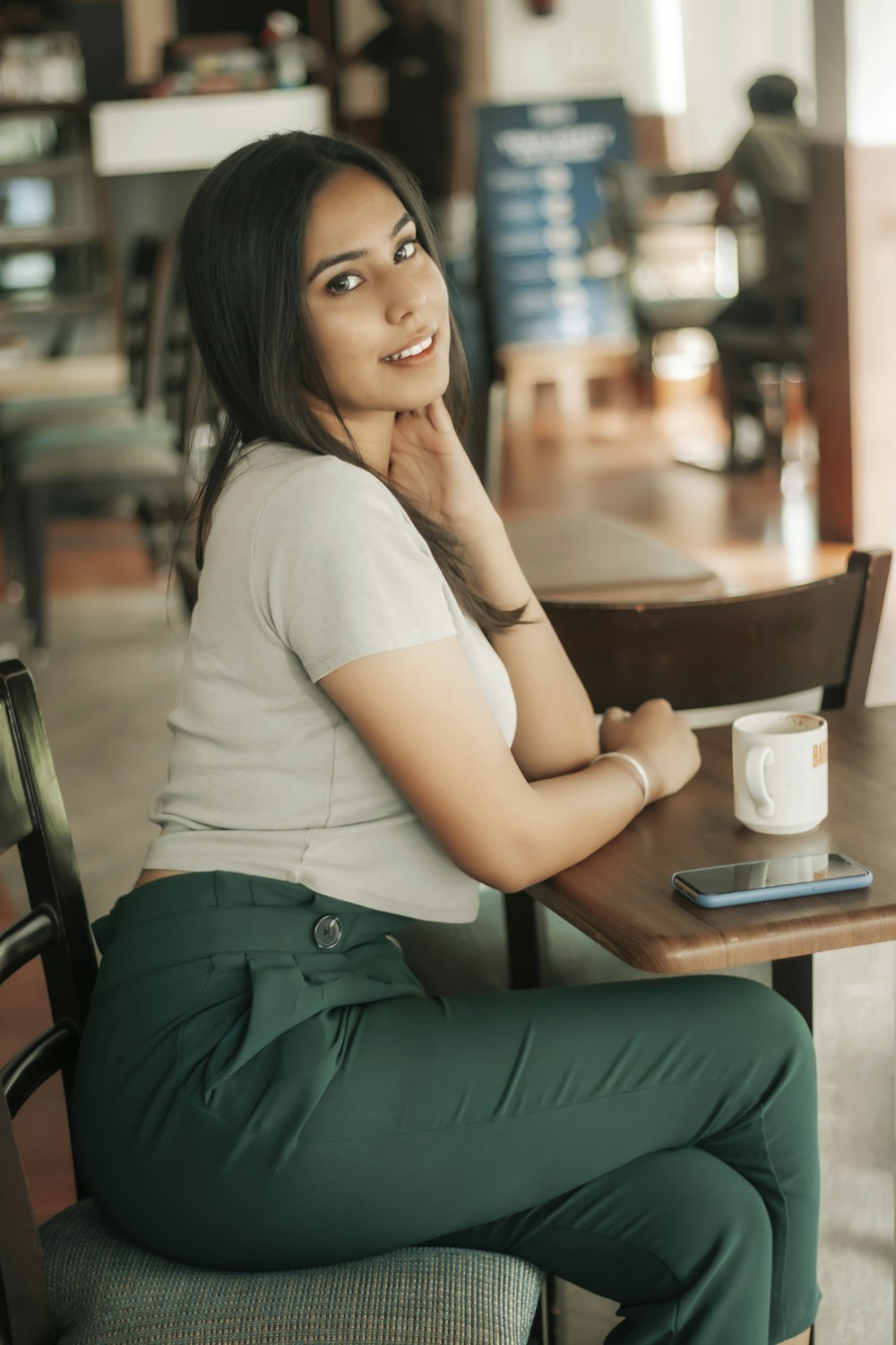 woman in white t-shirt and green skirt sitting on chair