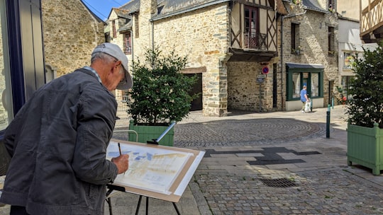man in gray jacket holding white and blue book in 44110 Châteaubriant France