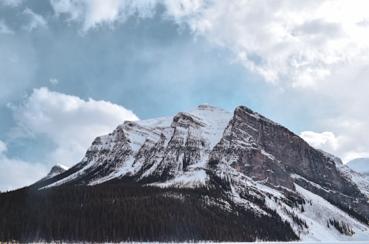 snow covered mountain under cloudy sky during daytime in Banff National Park Canada