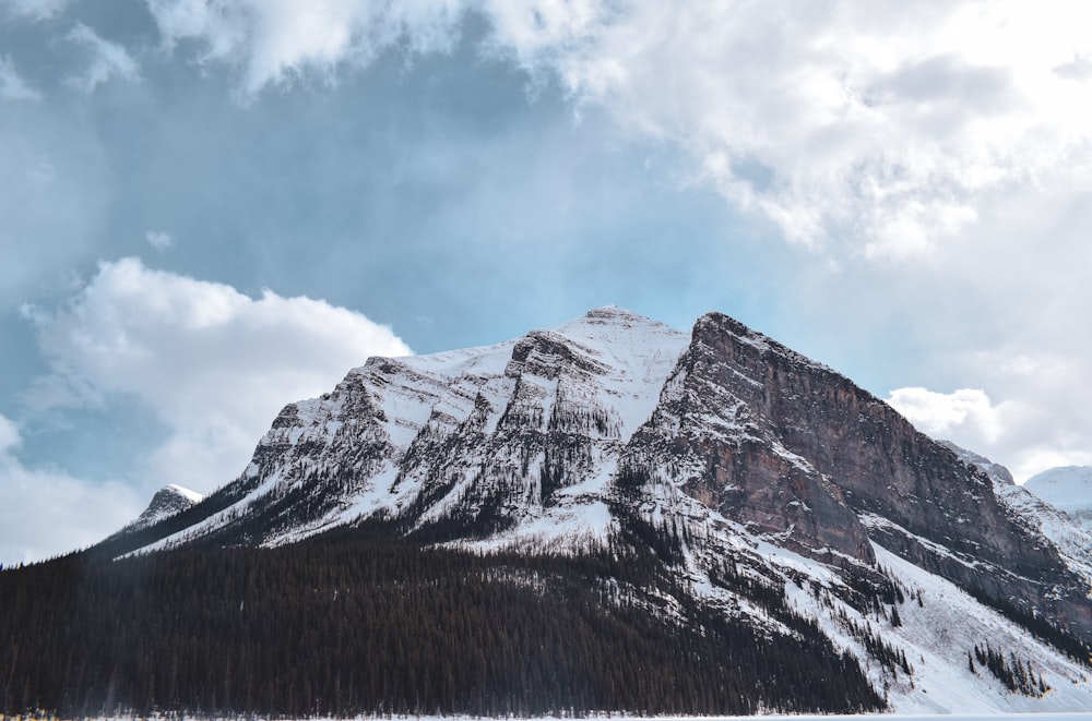 snow covered mountain under cloudy sky during daytime